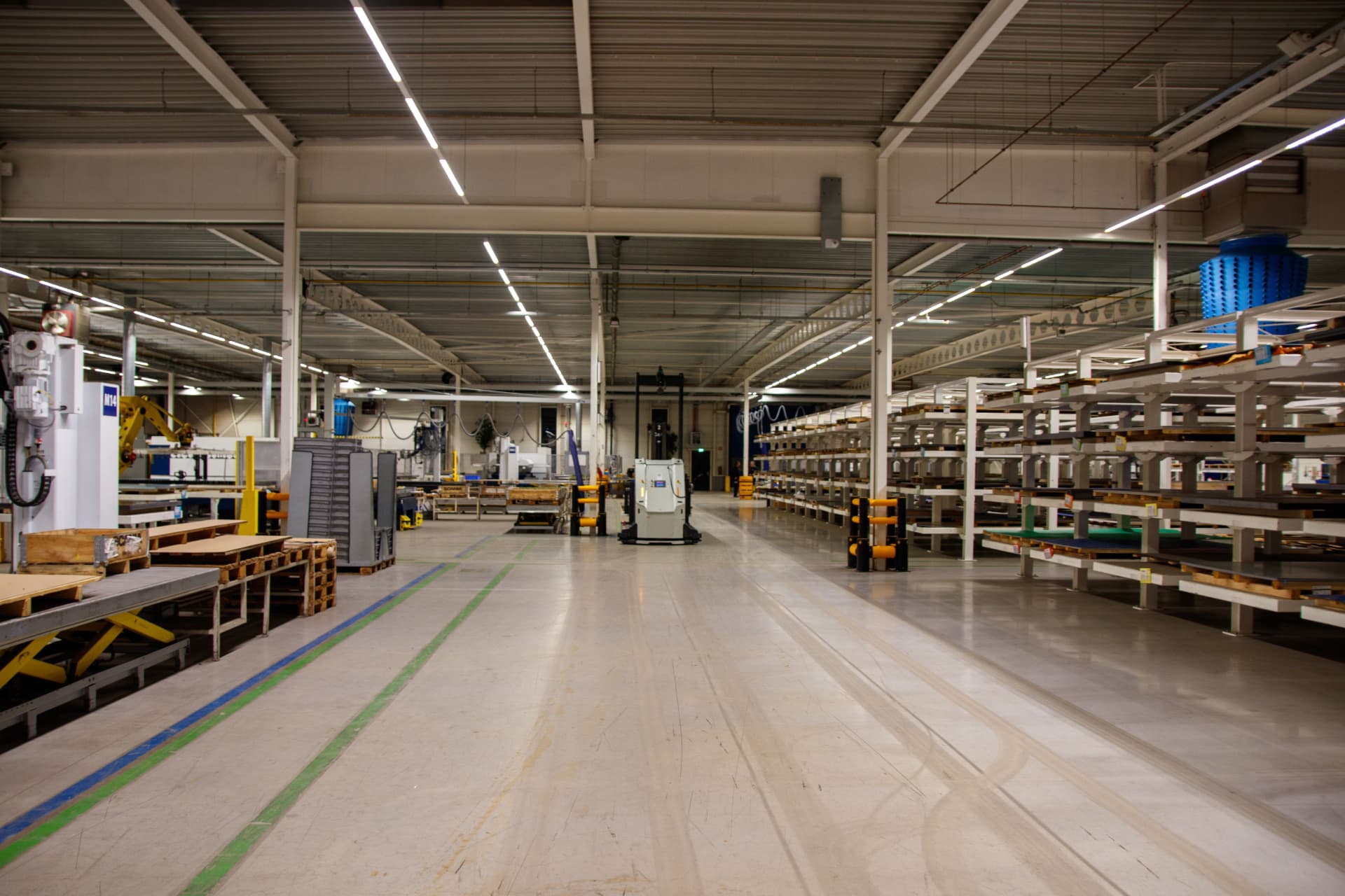 Warehousing, engineering and supply: a modern warehouse floor with racking, workstations and marked traffic lanes.